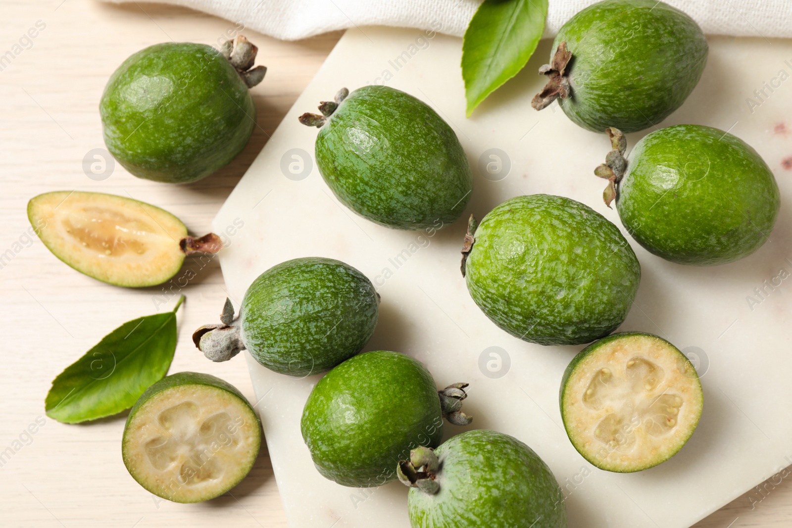 Photo of Flat lay composition with fresh green feijoa fruits on light table