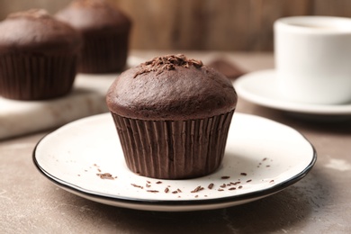 Photo of Delicious cupcake with chocolate crumbles on beige marble table, closeup