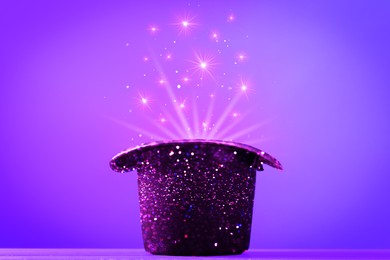 Image of Wizard's hat with magical light on violet background