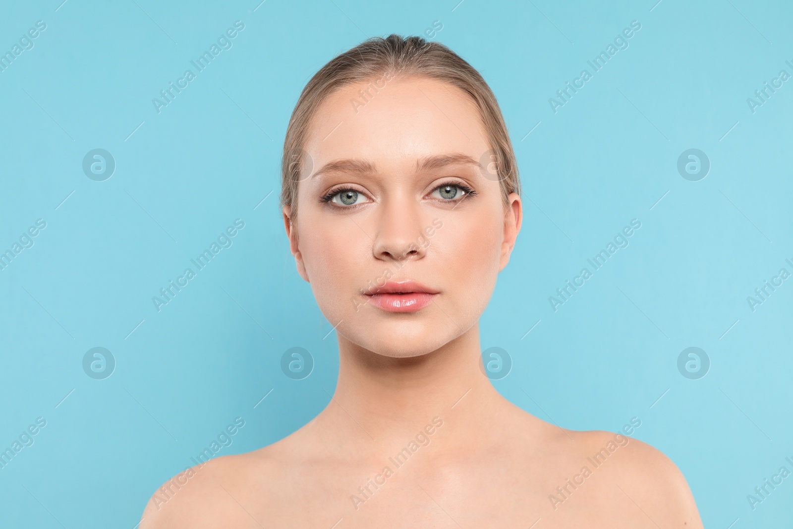 Photo of Portrait of young woman with beautiful face on blue background