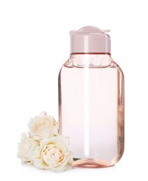Photo of Bottle of micellar cleansing water and flowers on white background