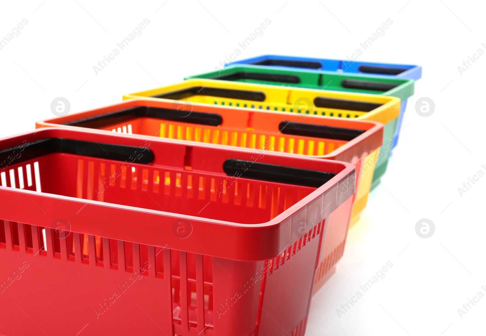 Photo of Colorful plastic shopping baskets on white background