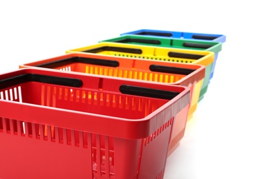 Photo of Colorful plastic shopping baskets on white background