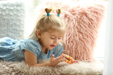 Cute little girl lying on fur plaid at home