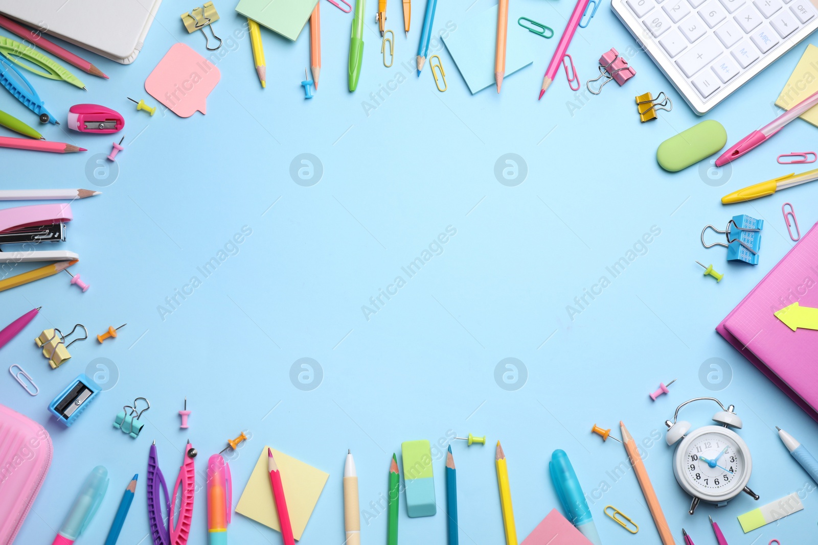 Photo of Frame of different stationery on light blue background, flat lay. Space for text