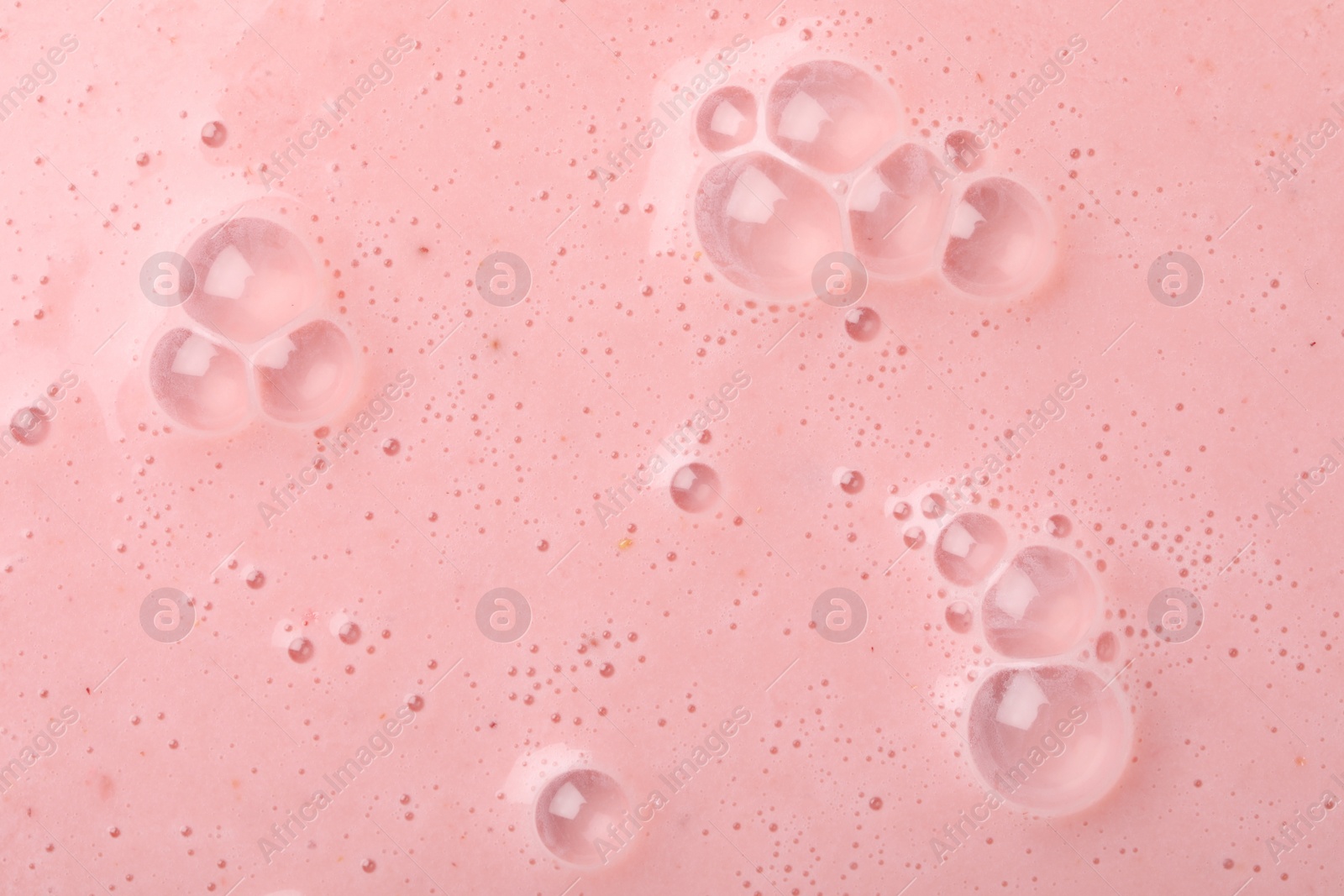 Photo of Tasty pink smoothie with bubbles as background, closeup