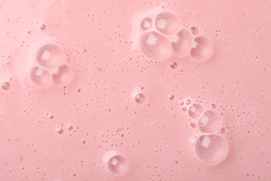 Photo of Tasty pink smoothie with bubbles as background, closeup