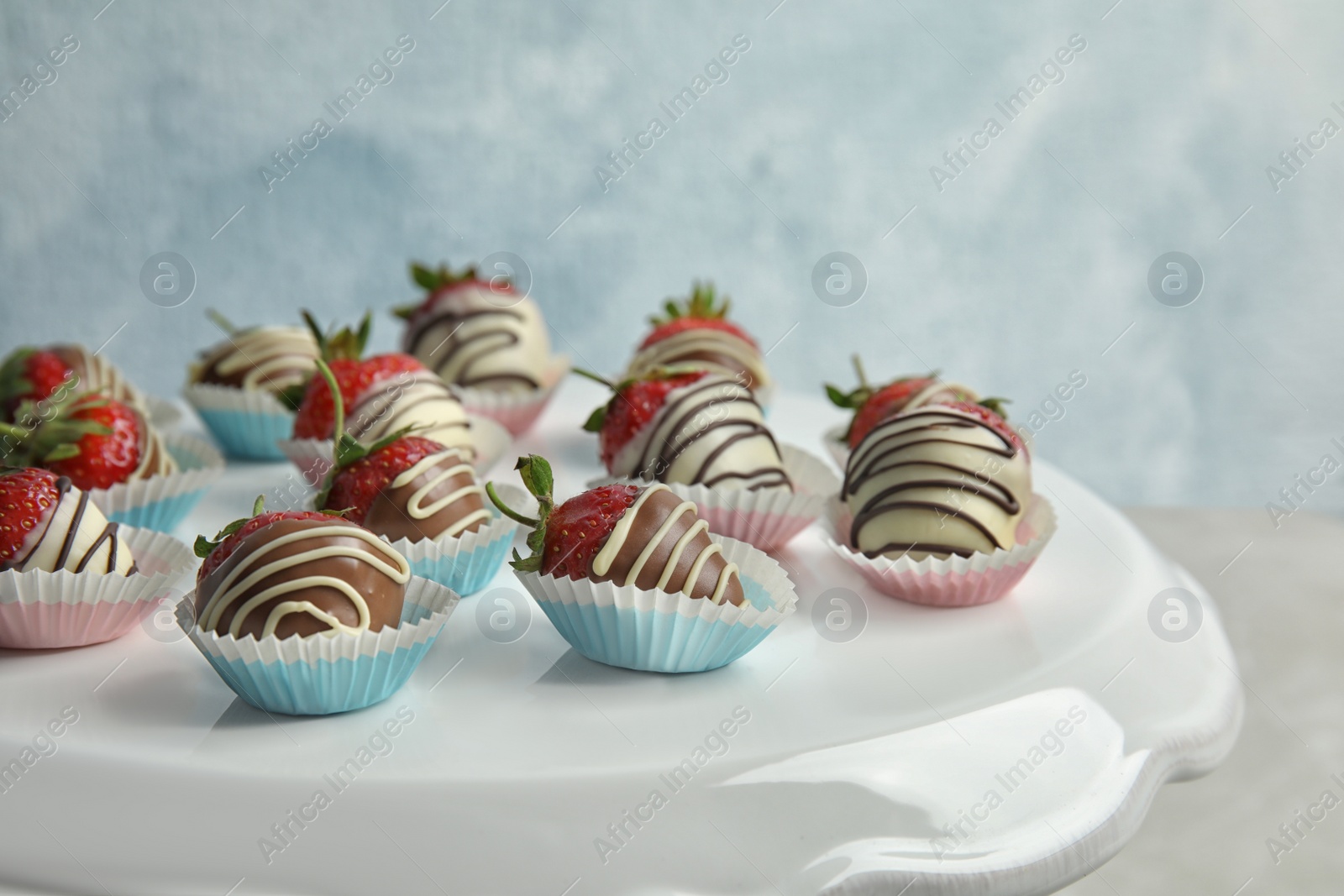 Photo of Dessert stand with chocolate covered strawberries on light background, closeup