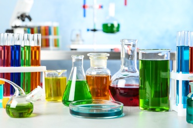 Photo of Different glassware with samples on table in chemistry laboratory