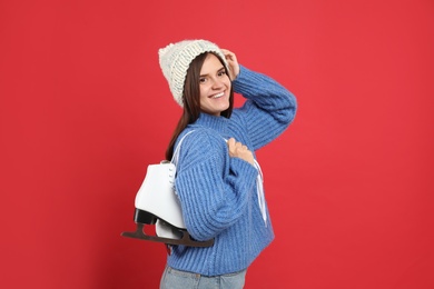 Photo of Happy woman with ice skates on red background