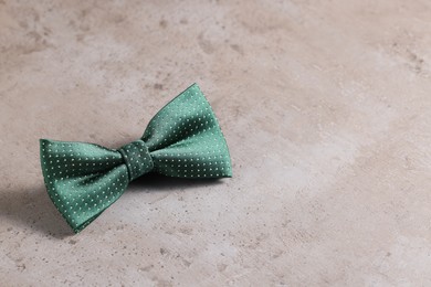 Photo of Stylish green bow tie on gray textured background, space for text