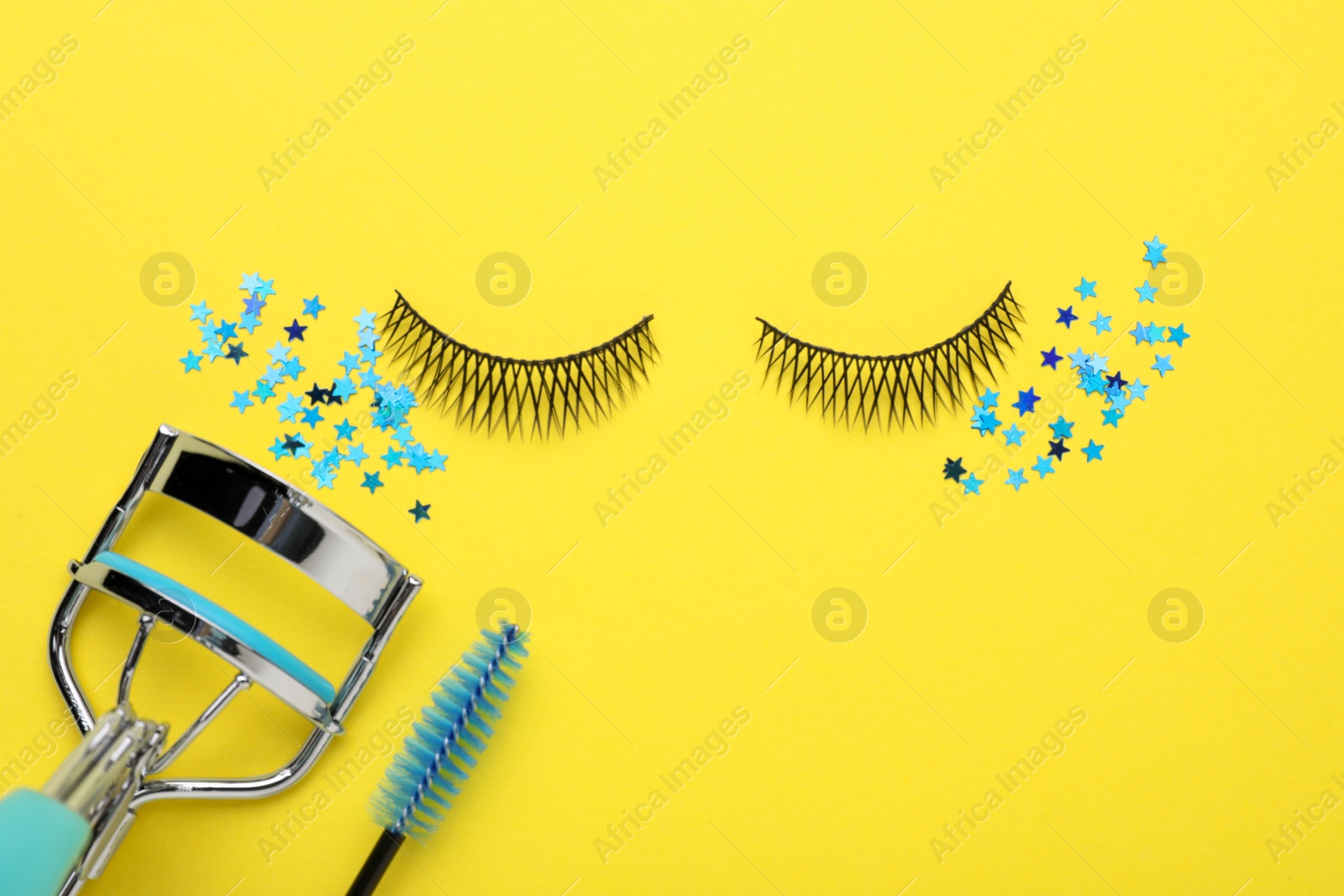 Photo of Flat lay composition with false eyelashes on yellow background