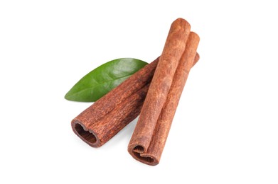 Photo of Cinnamon sticks and green leaf isolated on white