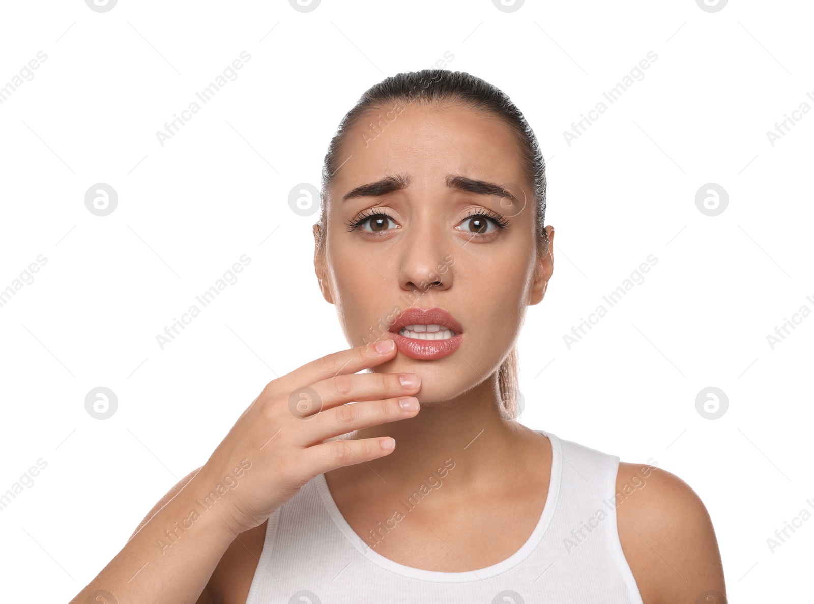 Photo of Emotional woman with herpes touching lips on white background