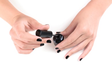 Woman applying nail polish on white background, closeup