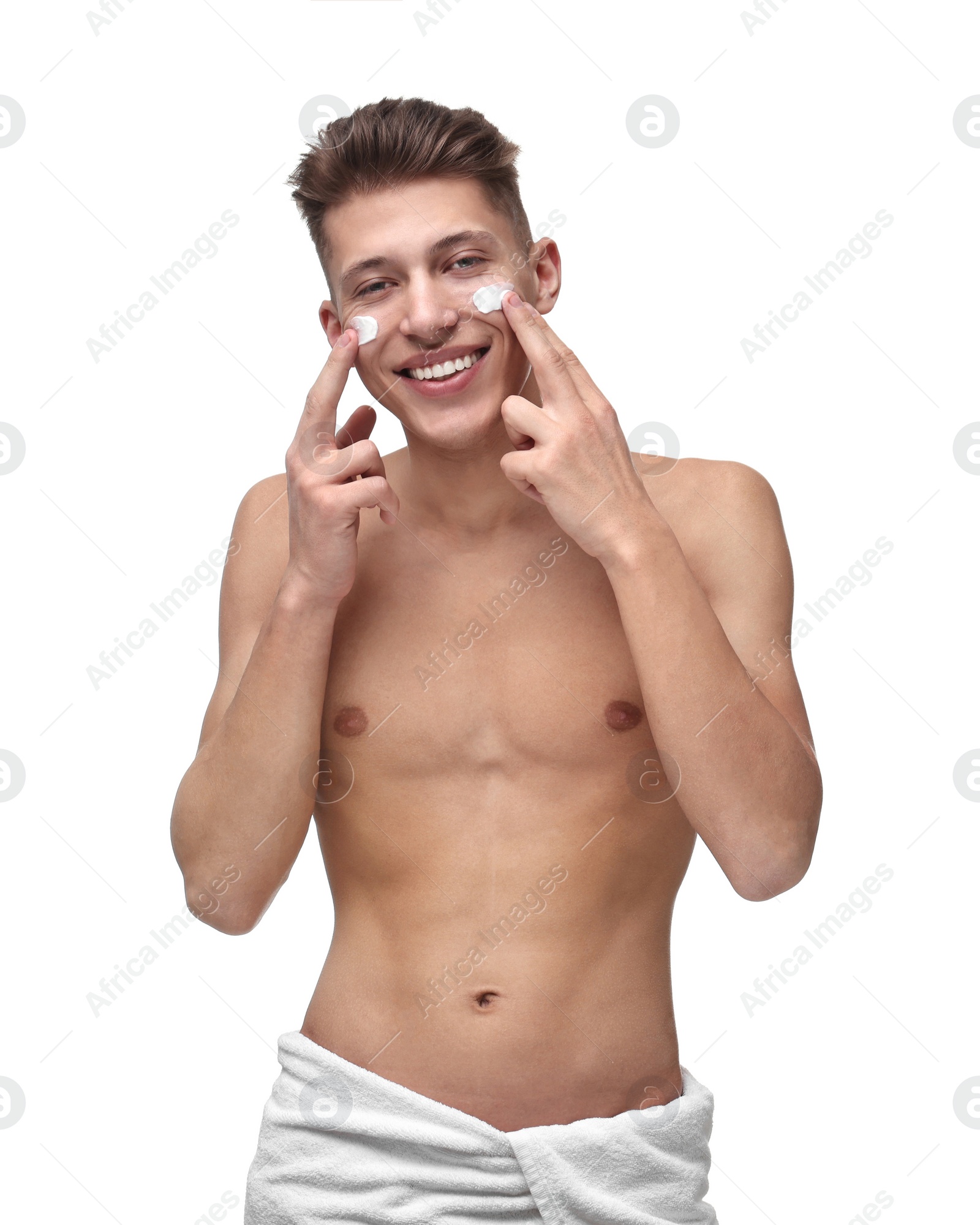 Photo of Handsome man applying moisturizing cream onto his face on white background