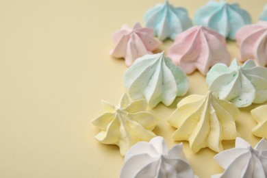 Photo of Delicious meringue cookies on beige background, closeup. Space for text