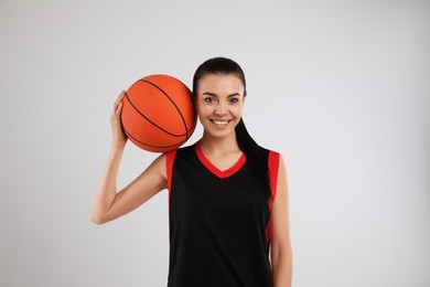 Basketball player with ball on grey background