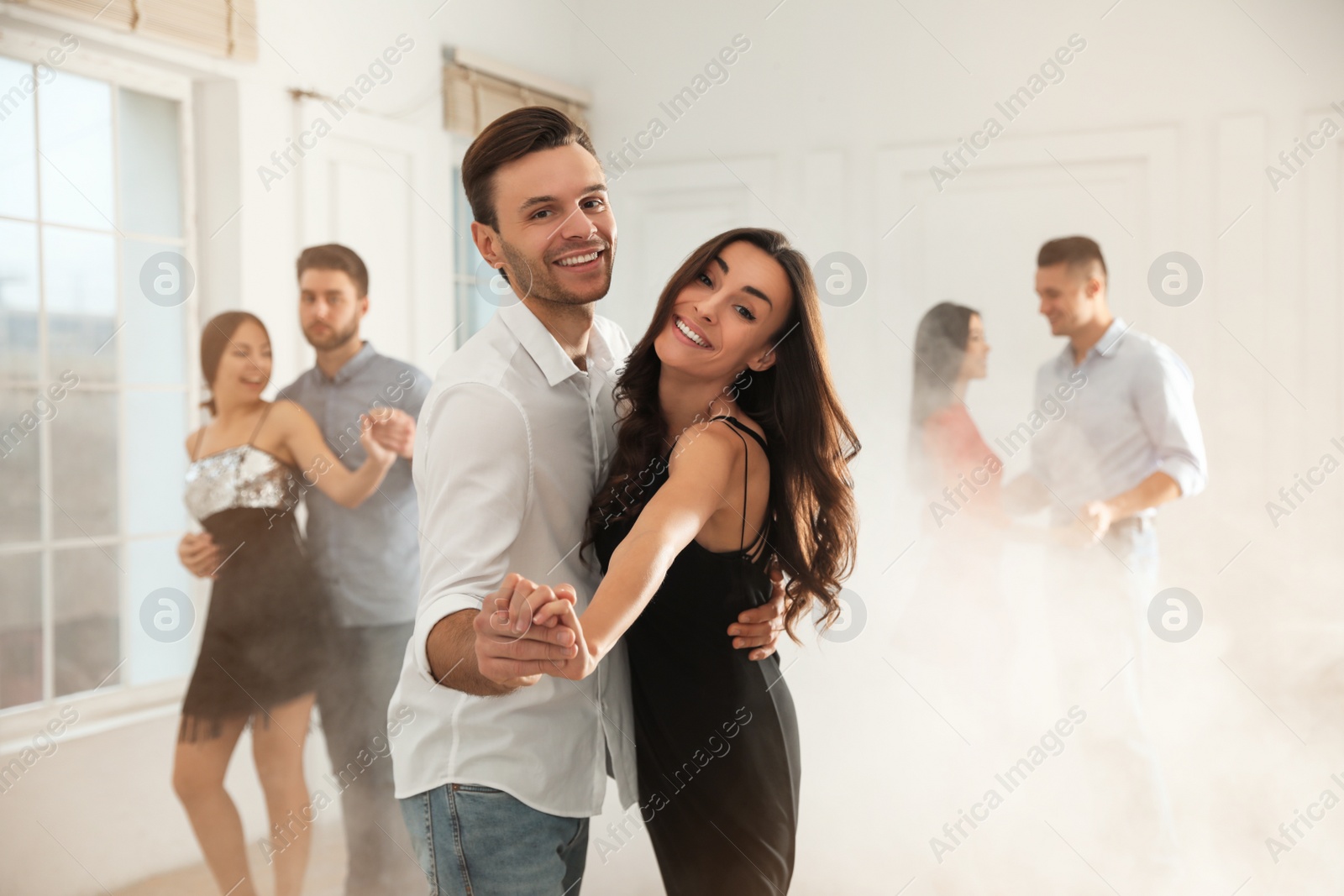 Photo of Lovely young couple dancing together at party