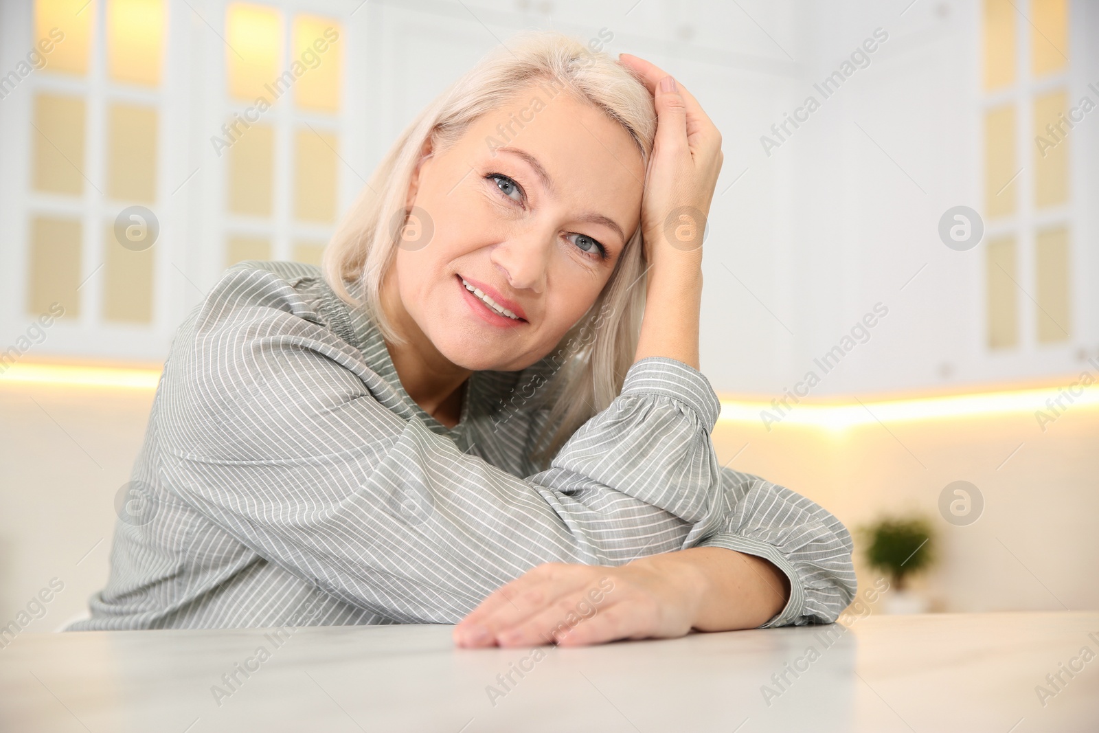 Photo of Portrait of beautiful mature woman in kitchen