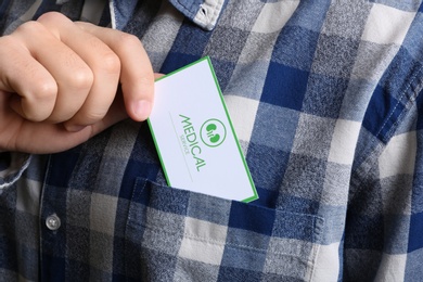 Photo of Man putting medical business card into pocket, closeup. Nephrology service