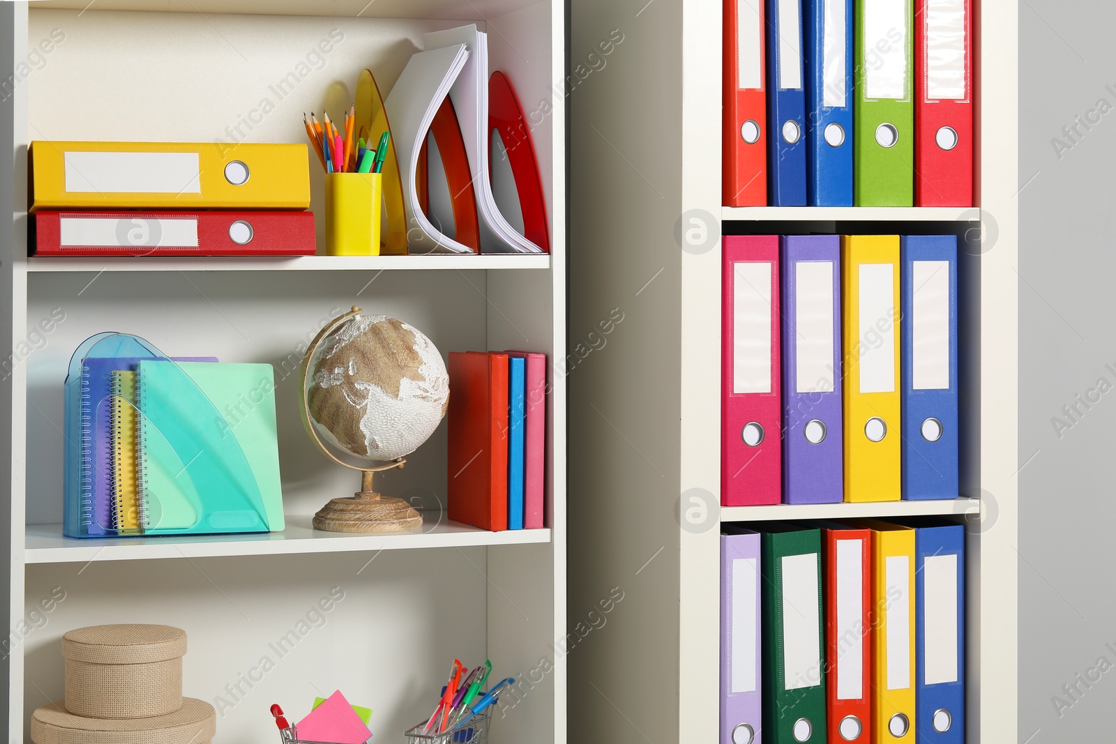 Photo of Colorful binder office folders and other stationery on shelving unit