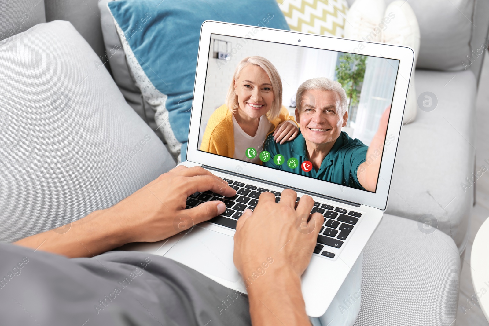 Image of Young man having video chat with his grandparents at home, focus on screen