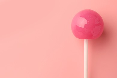 One tasty lollipop on pink background, top view. Space for text