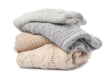 Photo of Stack of folded knitted sweaters on white background