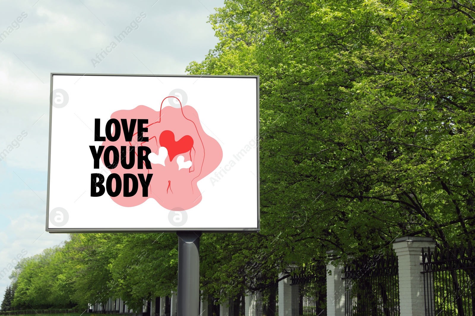 Image of Signboard with outline of woman figure, hearts and phrase Love Your Body on city street