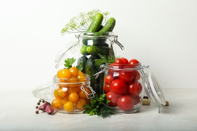 Photo of Pickling jars with fresh vegetables on light table