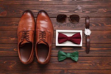 Flat lay composition with stylish color bow ties on wooden background