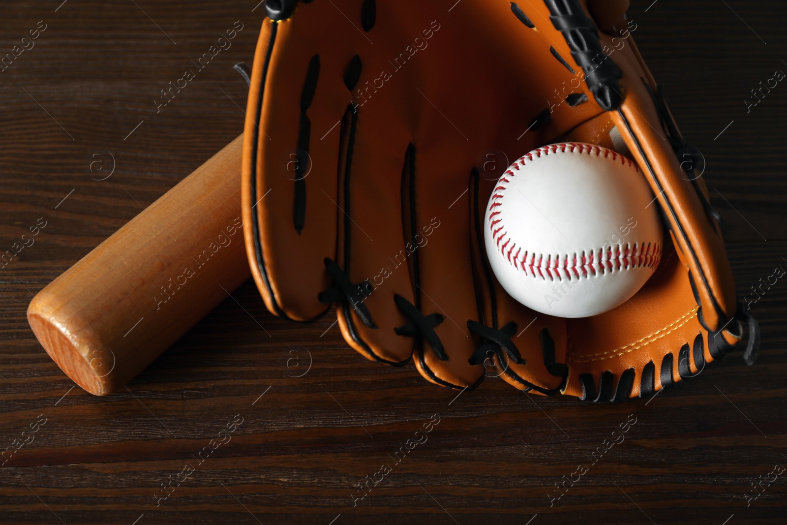 Photo of Leather baseball ball, bat and glove on wooden table