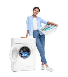 Beautiful woman with laundry basket near washing machine on white background