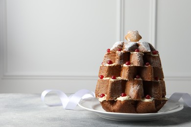 Delicious Pandoro Christmas tree cake with powdered sugar and berries on white table. Space for text