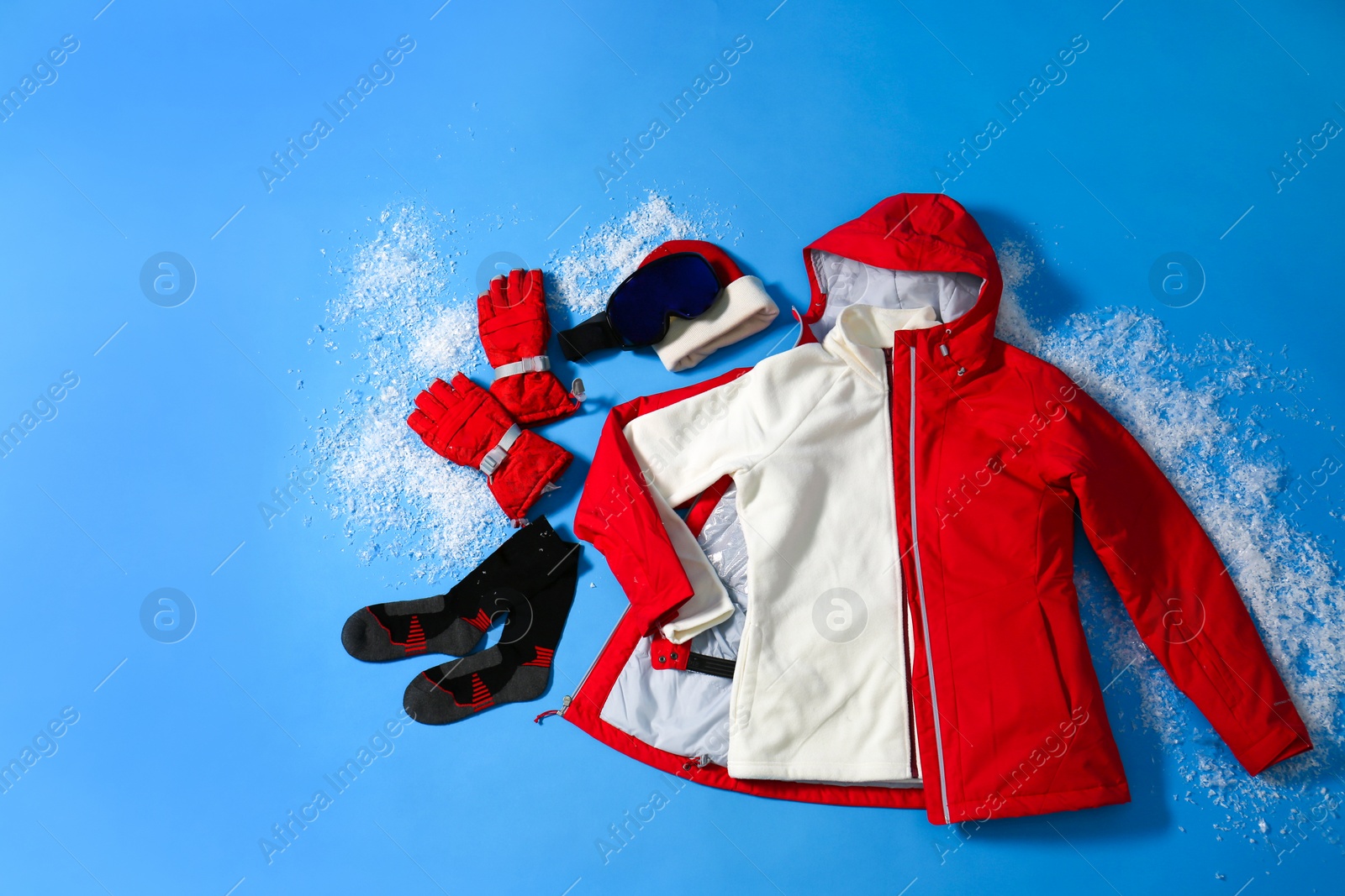 Photo of Stylish winter sport clothes on light blue background, flat lay