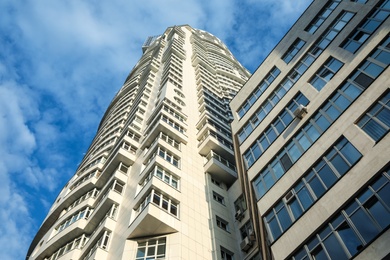 KYIV, UKRAINE - MAY 23, 2019: Modern dwelling building against sky with clouds