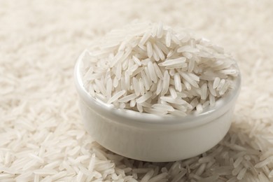 Photo of Bowl on raw basmati rice, closeup view. Space for text