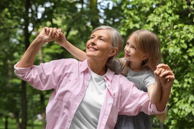 Happy grandmother with her granddaughter spending time together outdoors