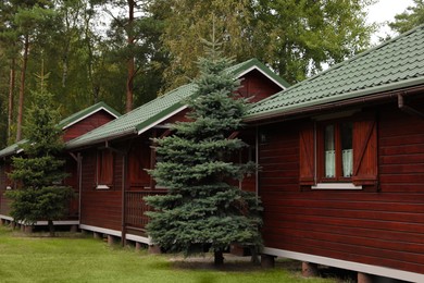 Photo of Beautiful wooden beach houses and green trees outdoors