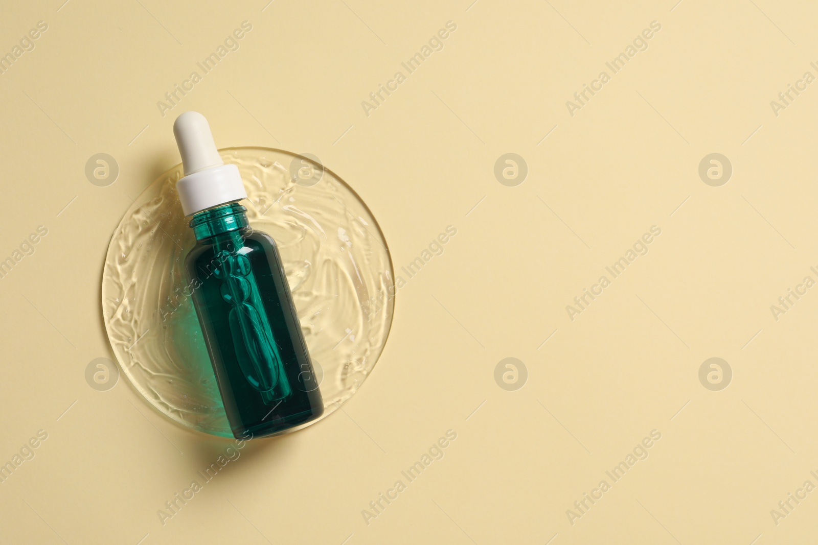 Photo of Bottle of cosmetic serum on beige background, top view. Space for text