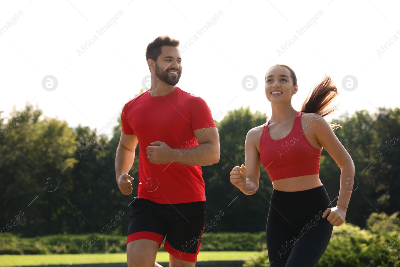 Photo of Healthy lifestyle. Happy couple running in park on sunny day