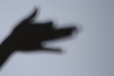 Photo of Shadow of hand like dog on grey background. Space for text