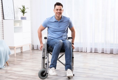 Happy man sitting in wheelchair at home