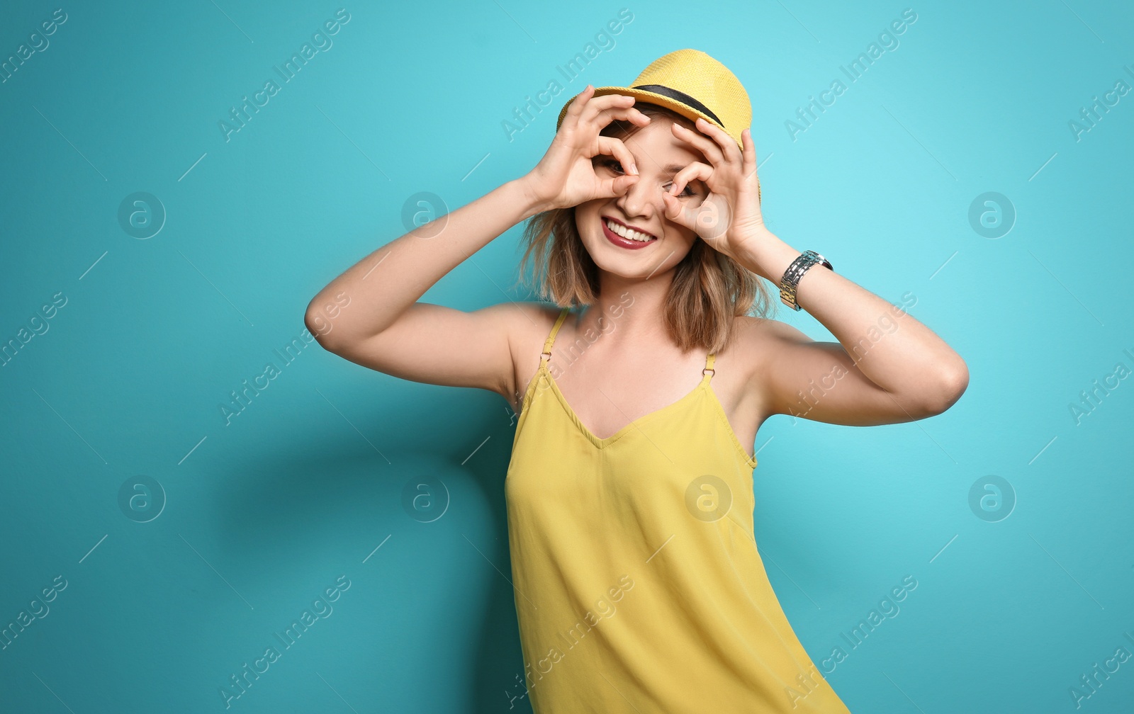 Photo of Beautiful young woman with stylish hat posing on color background