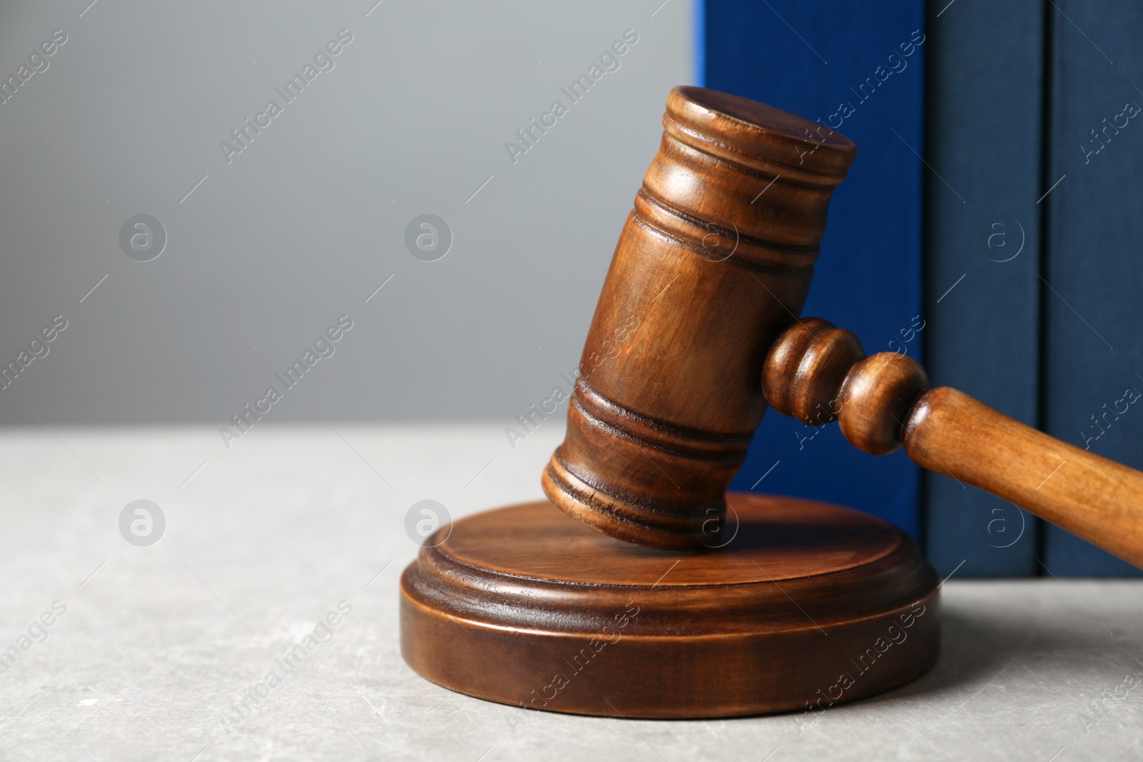 Photo of Wooden gavel and books on table, closeup. Law concept