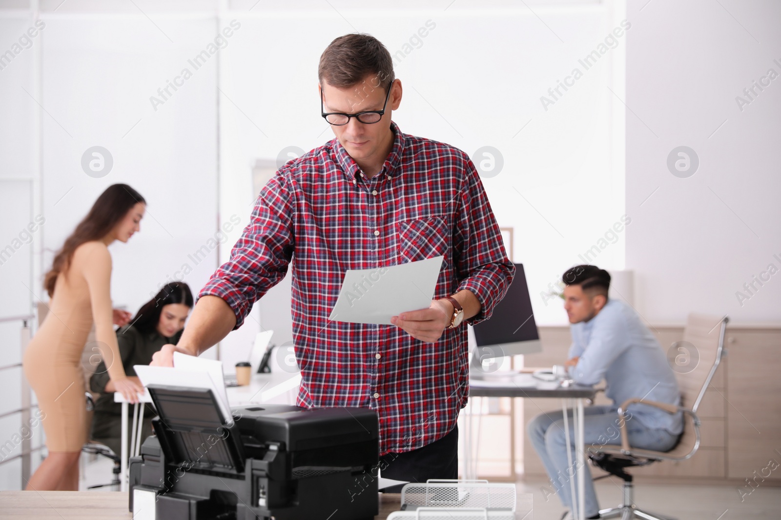 Photo of Employee using new modern printer in office