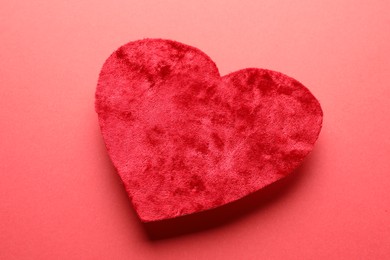 Photo of One velvet heart on red background, closeup