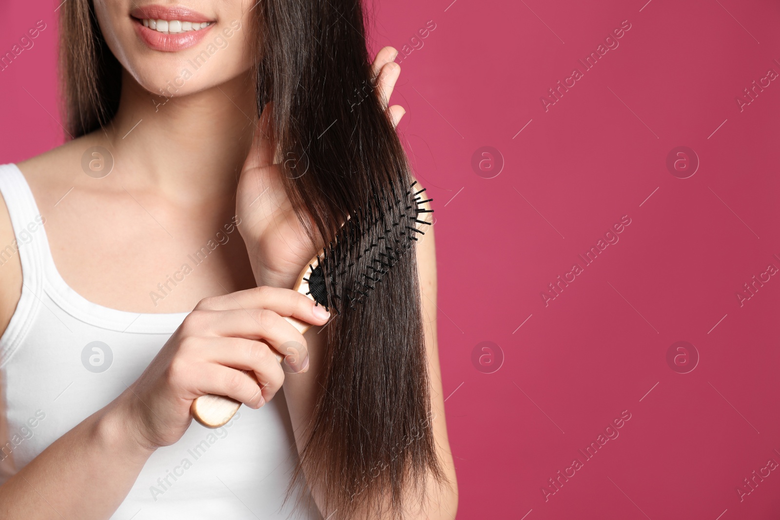 Photo of Woman with hair brush on color background, closeup. Space for text