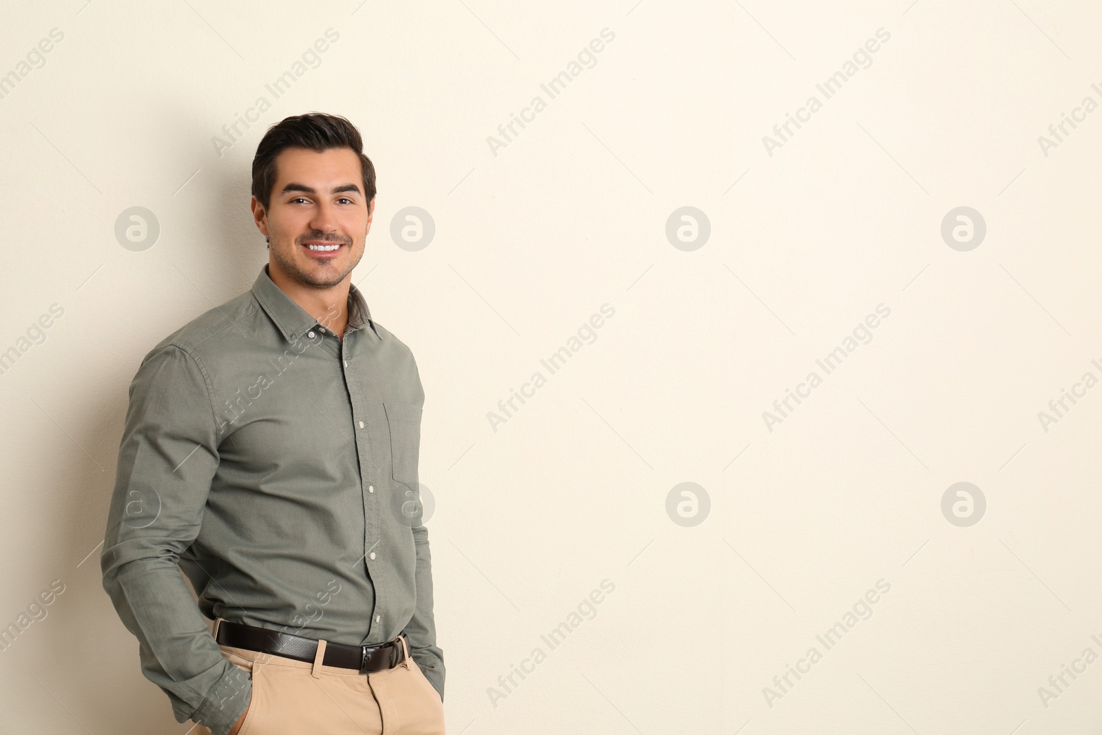 Photo of Young male teacher on beige background. Space for text